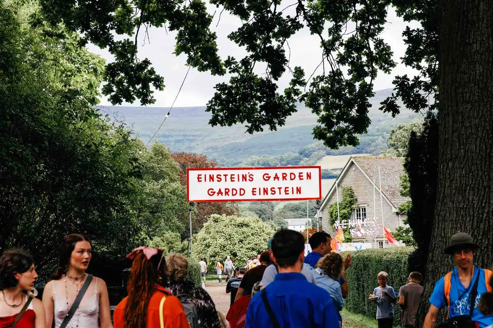 people walk underneath a sign for Einstein's Garden
