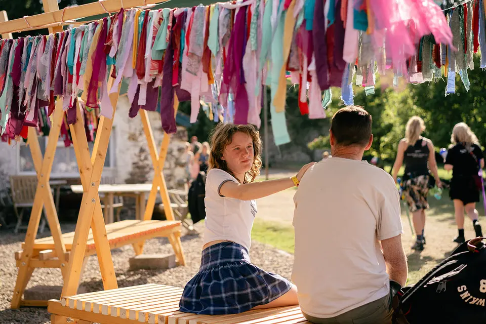 people are sat on a bench covered in fabric bunting scraps