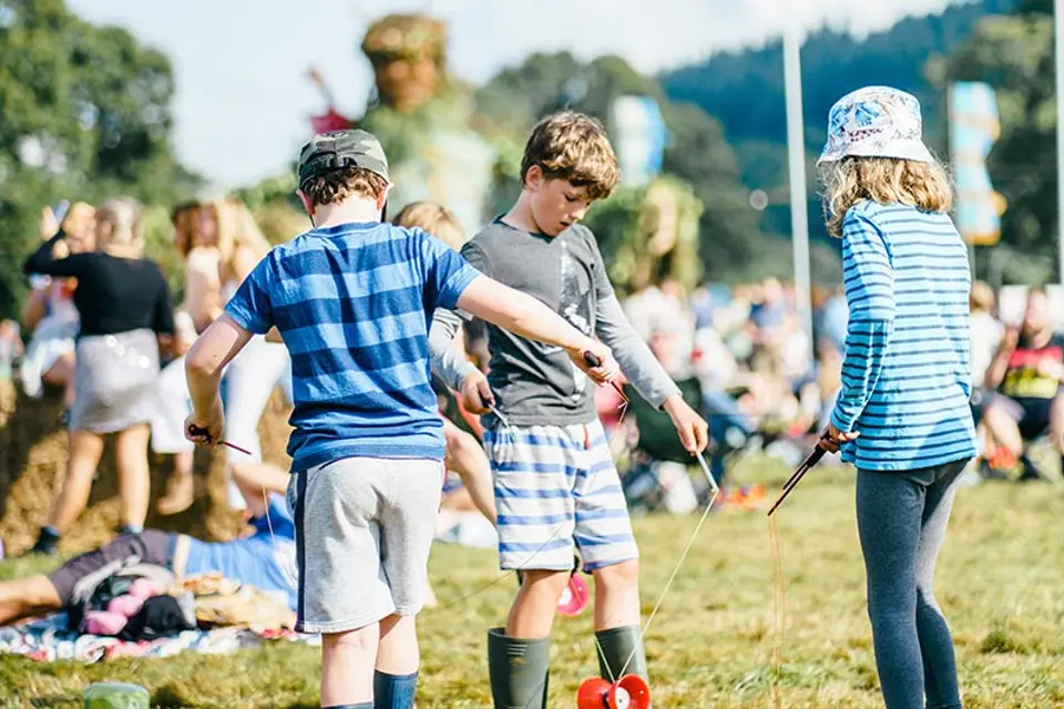 three children are playing with a diabolo toy