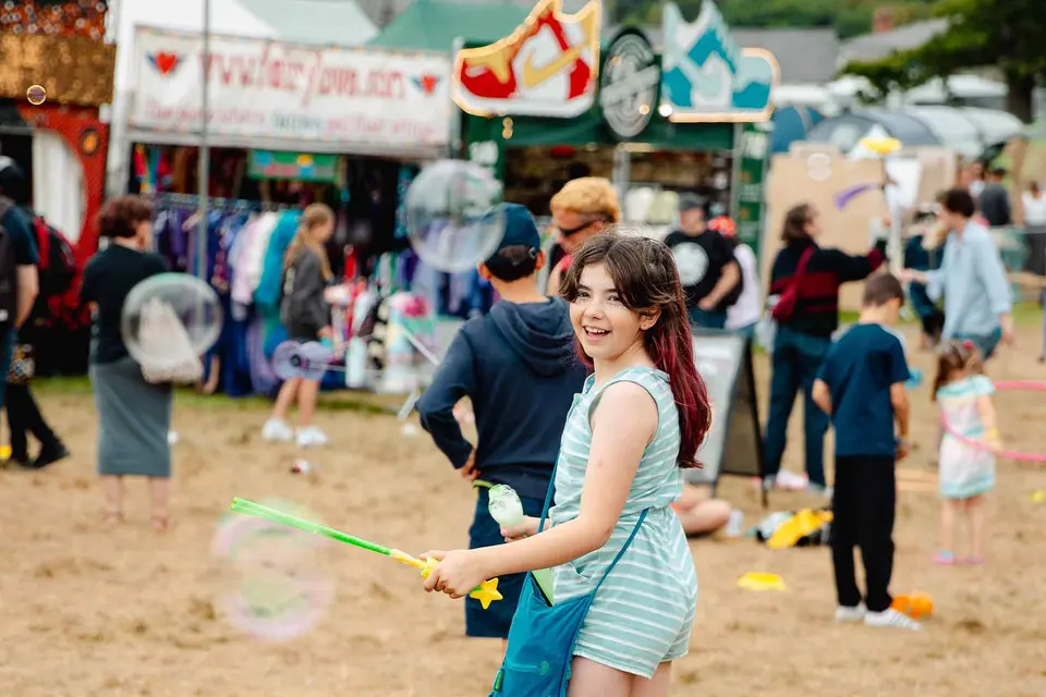 a girl with pink hair blows bubbles