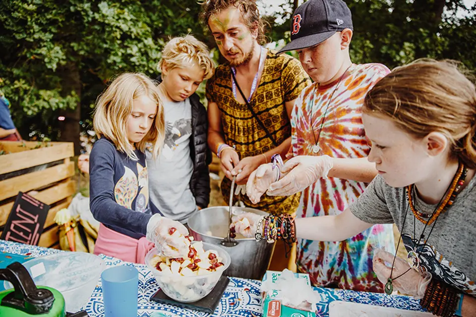 kids mix fruit into a mixing bowl