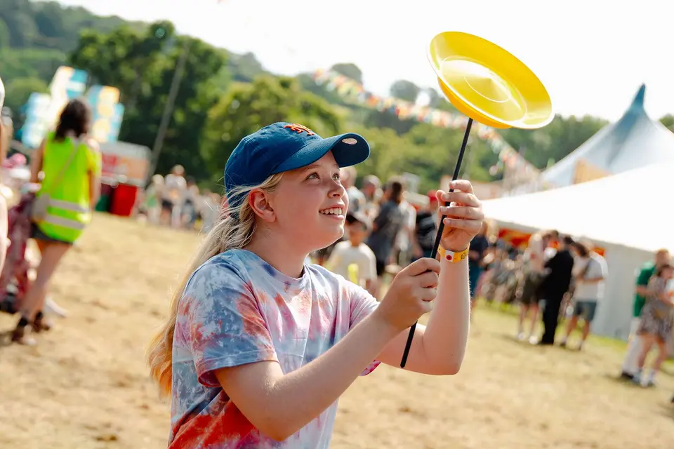 a girl in a tie dye top spins a plate