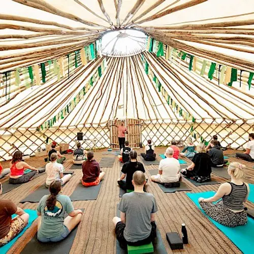 People doing yoga in a large tent