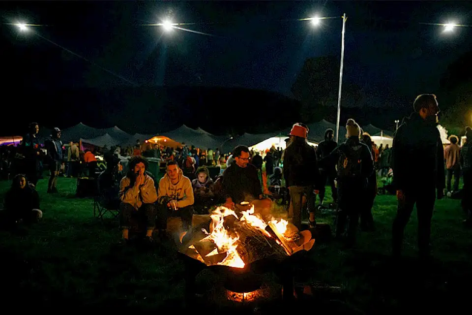People sitting around the fire at Green Man Festival