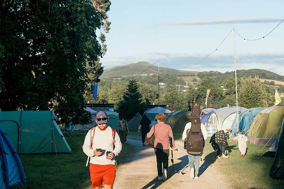 Campers walking through campsite at Green Man