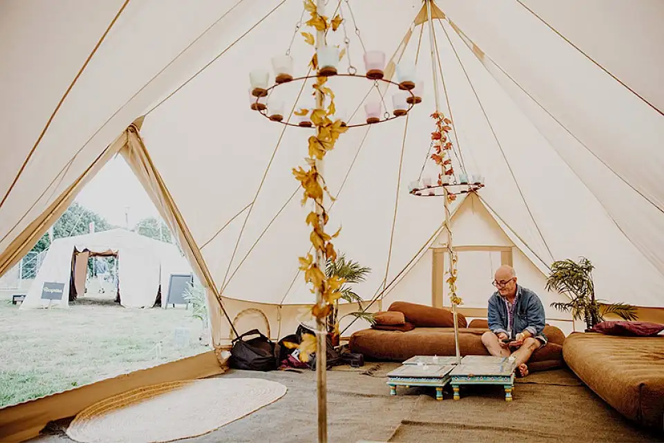 Inside a bell tent with a man sitting on sofa