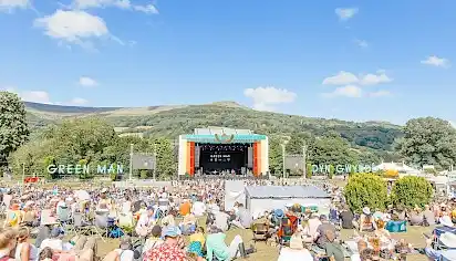 People sat at the Mountain's Foot area with the stage in the distance