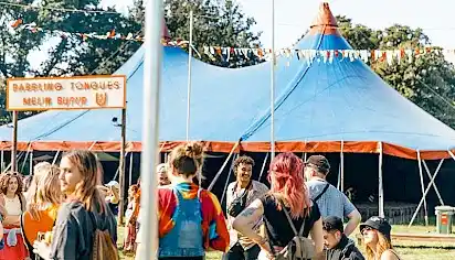 People stand outside the blue and red Babbling Tongues tent