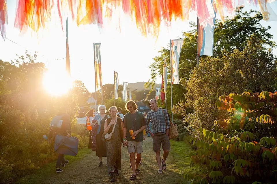 Groups walk through Einstein's Garden at golden hour with bunting above