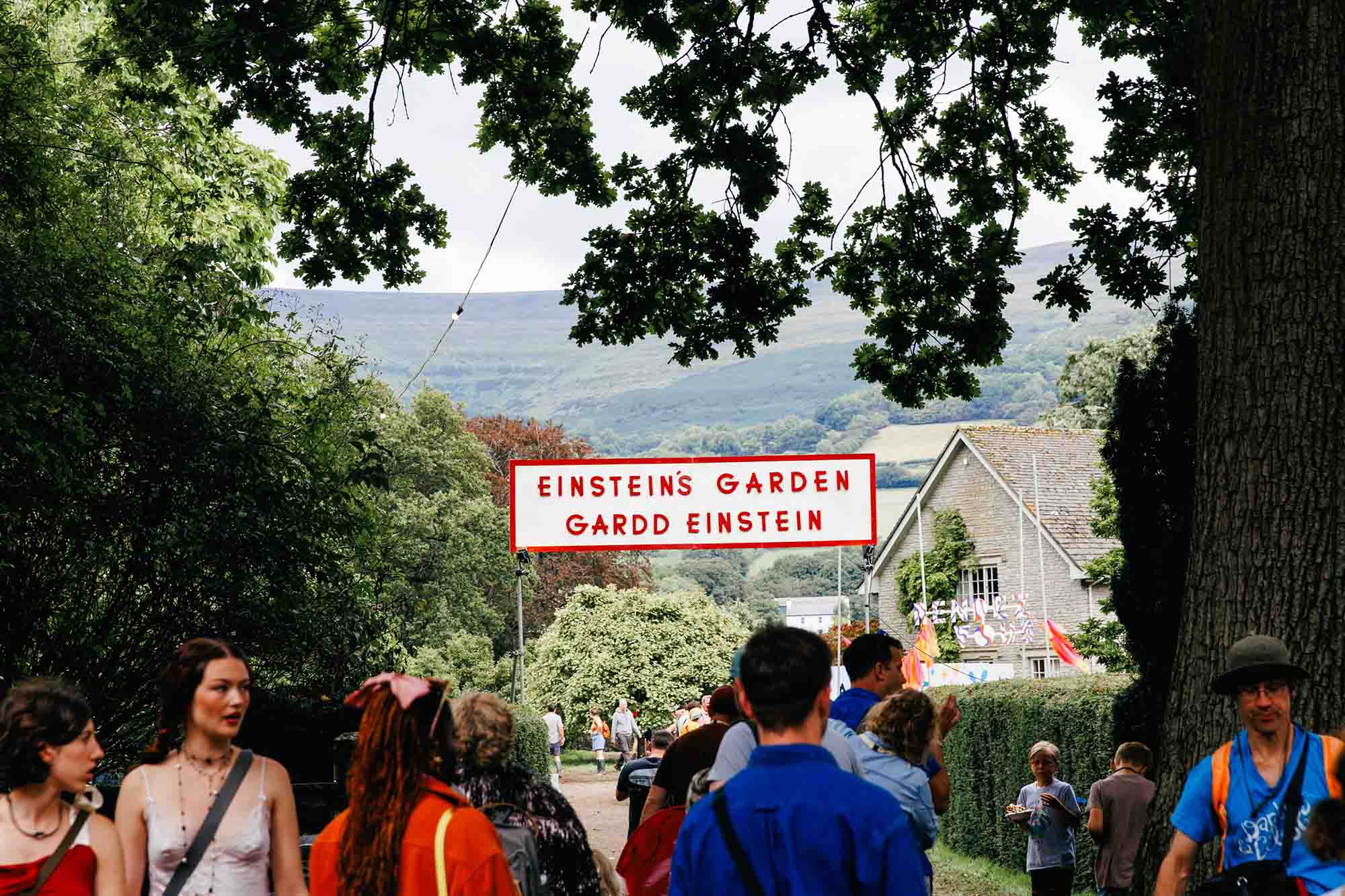 people walk underneath a sign for Einstein's Garden