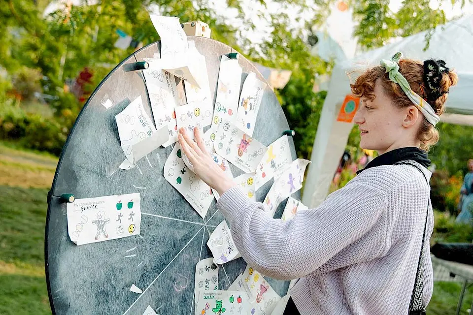 a girl is looking at cards on a large wheel