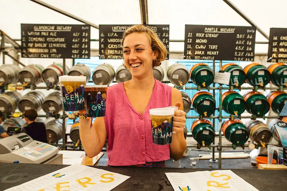 a woman serving pints from the courtyard bar