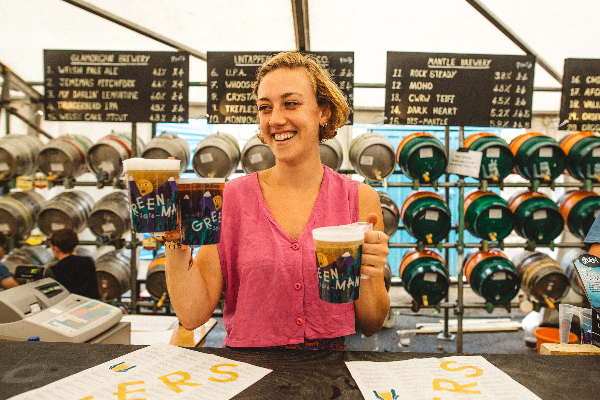 a woman serving pints from the courtyard bar