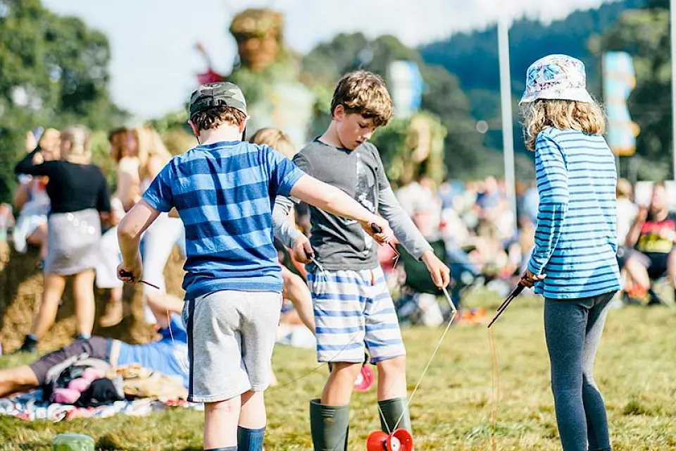 three children are playing with a diabolo toy