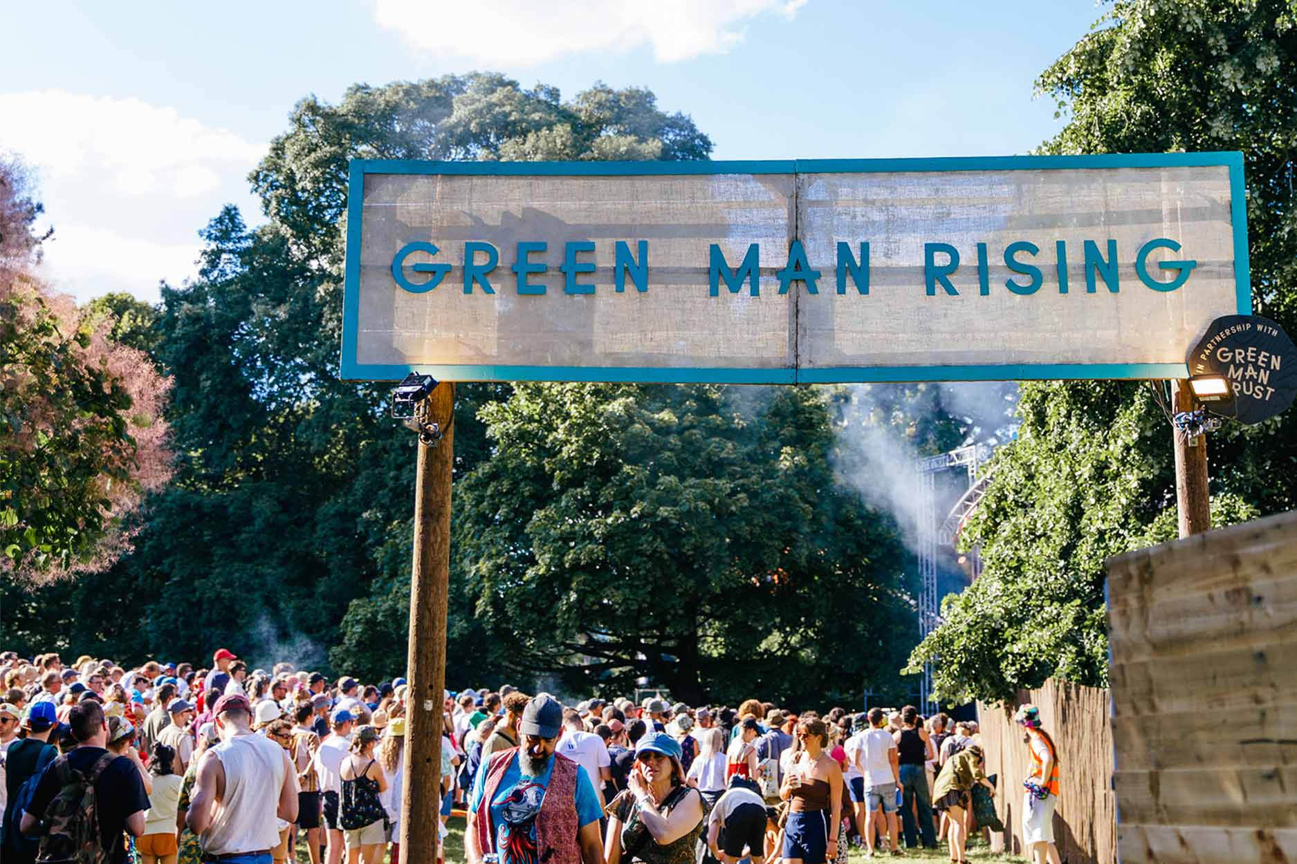 people underneath the green man rising sign