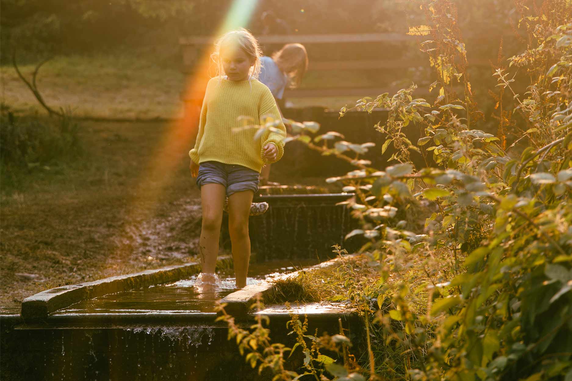 a child paddling in the stream