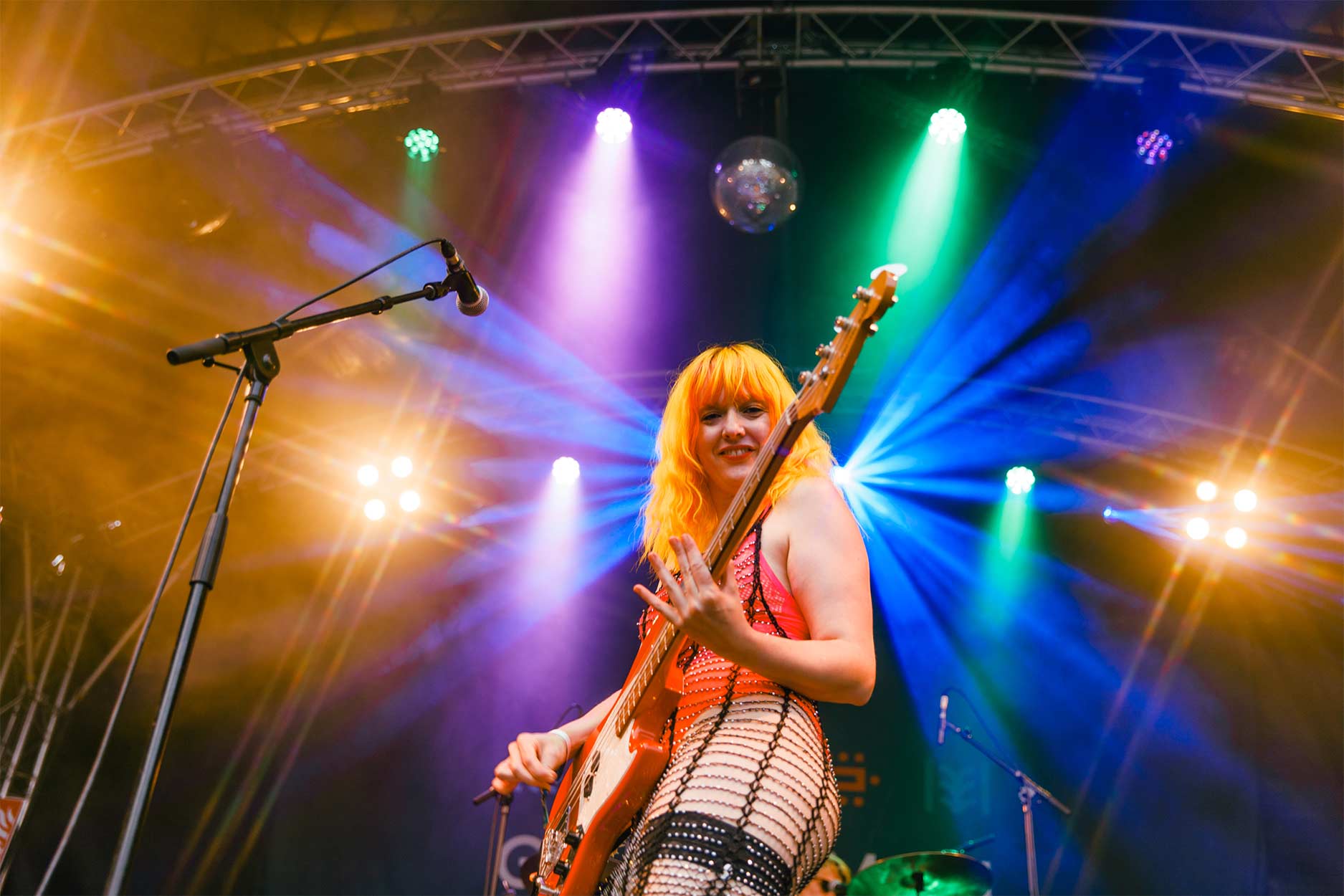 a woman plays guitar on the rising stage