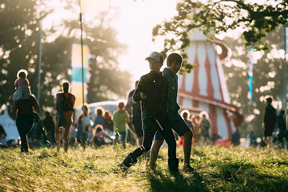 two boys walk past the helter skelter