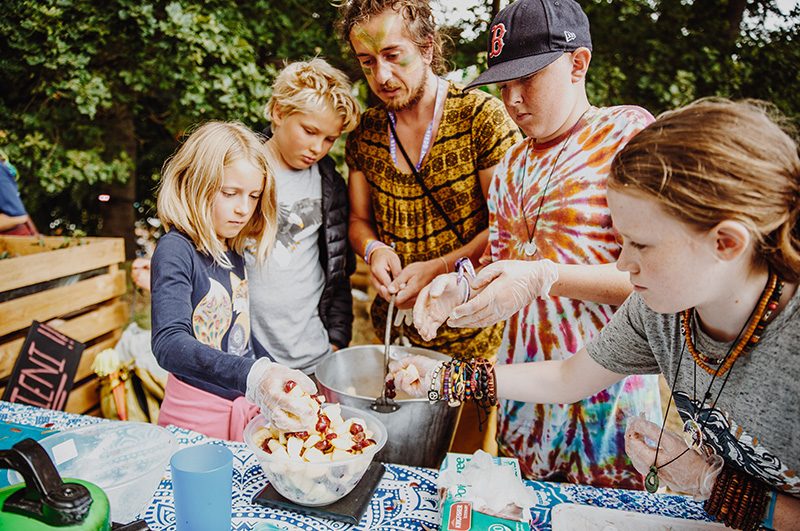 kids mix fruit into a mixing bowl