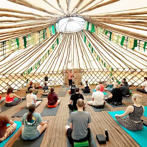 People doing yoga in a large tent