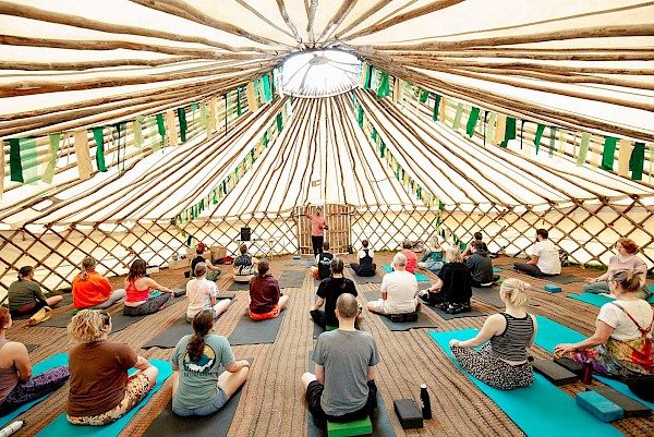People doing yoga in a large tent