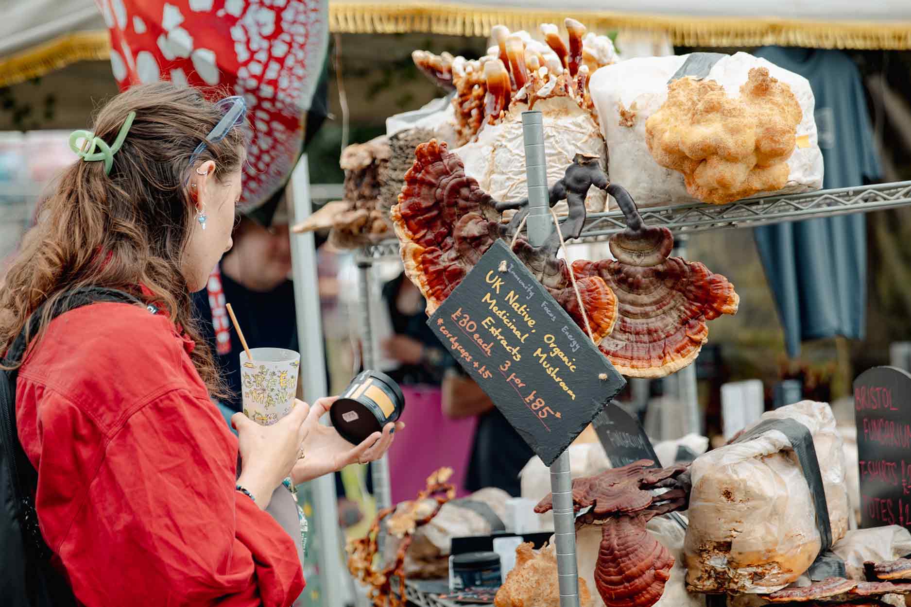 a women is looking at mushrooms on shelves