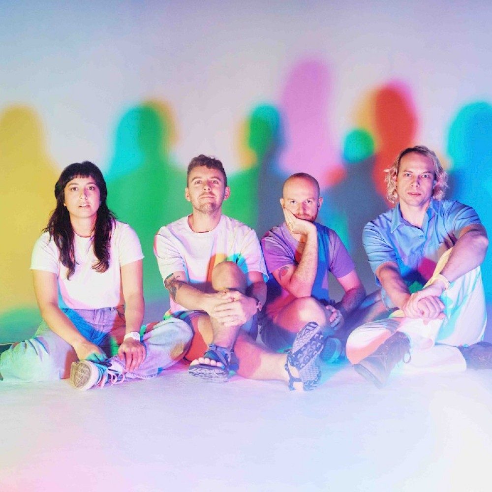 The Beths sat with a multicoloured background