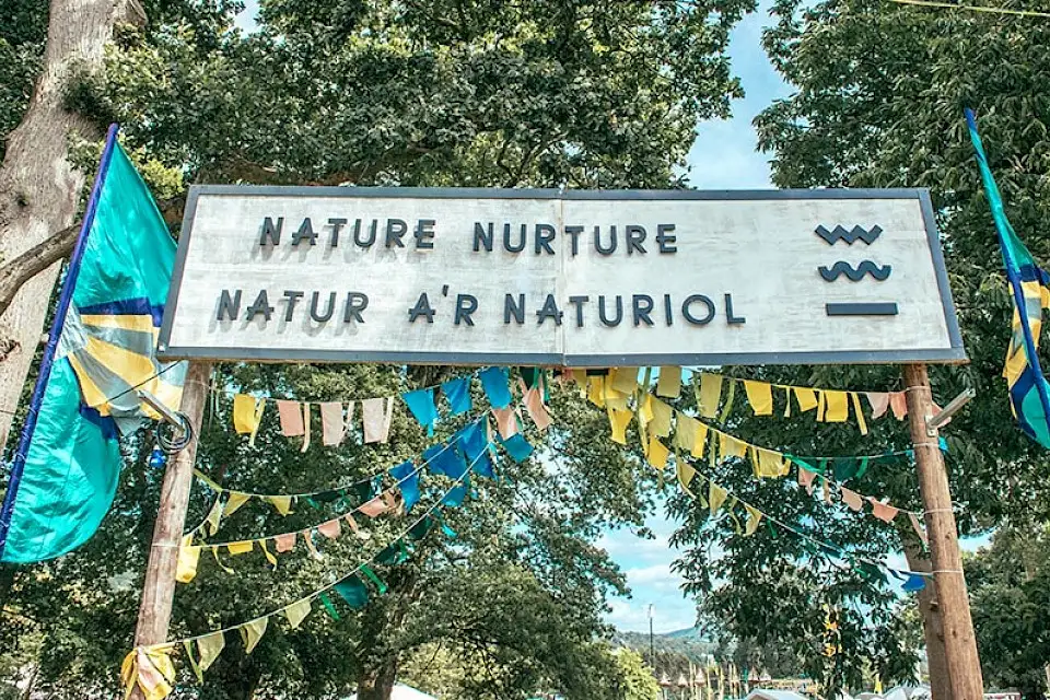 The large 'Nature Nurture - Natur A'R Naturiol' sign with pink, yellow and blue bunting underneath it