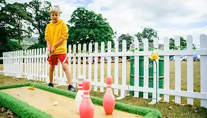 A boy plays minigolf