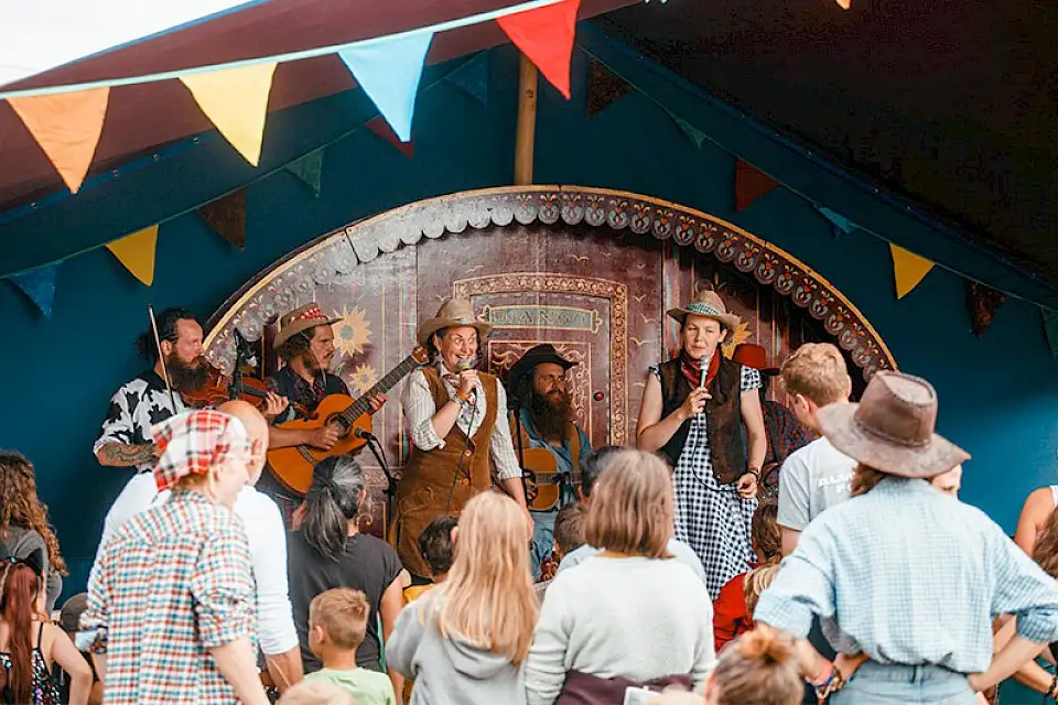 A band dressed as cowboys perform to families