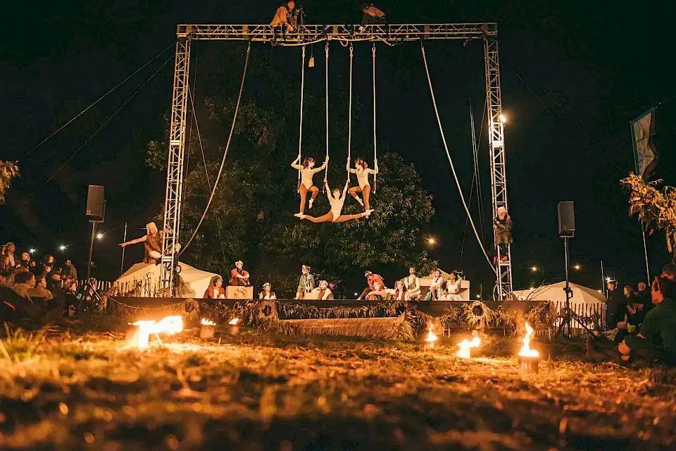 Three trapeze artists on the performing arts stage at night